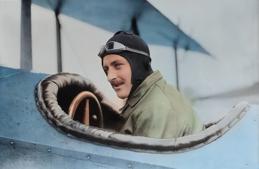 Originally from the Library of Congress, this AI recoloured photograph depicts early aviator Steve MacGordon circa 1915 in the cockpit of a biplane shortly before his death. MacGordon was one of the earliest pioneers in aviation and held many of the inaugural records in flight. by Party Plan Checklist man inside biplane