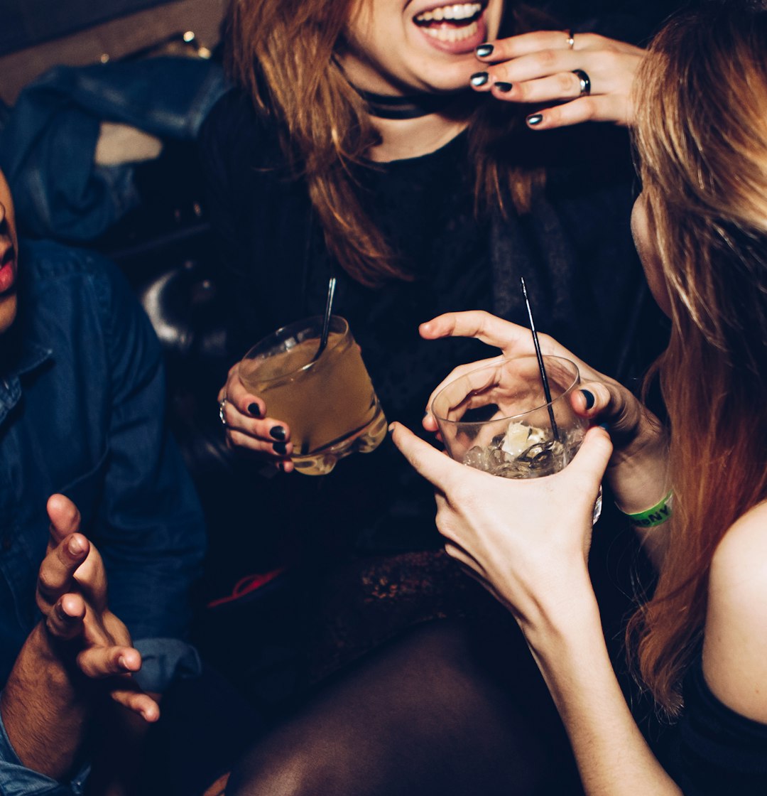 Closeup of drinks at the club by Party Plan Checklist two women talking while holding drinking glasses