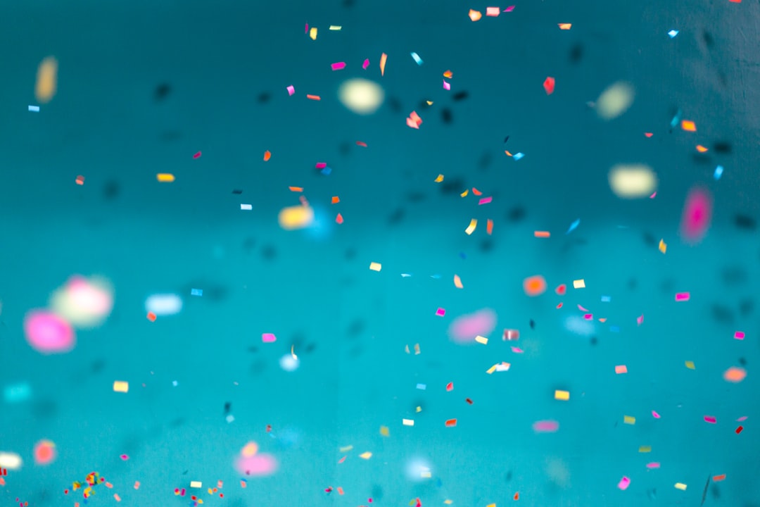 Colorful confetti falling down with a teal background by Party Plan Checklist selective focus photography of multicolored confetti lot